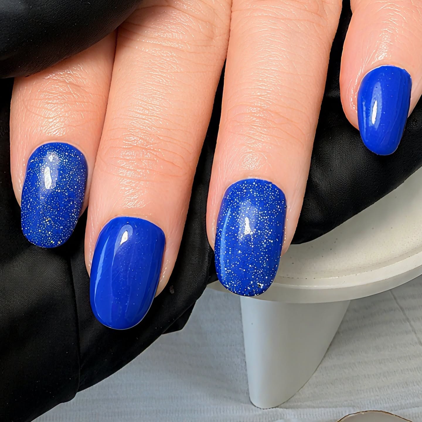 Royal blue nail polish with gold glitter accent designs